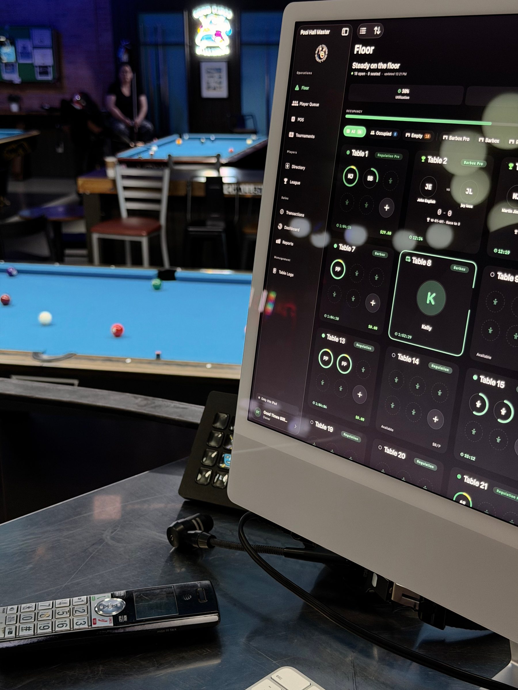 Pool Hall Master on an iMac at the desk at Good Times Billiards, with tables in the background